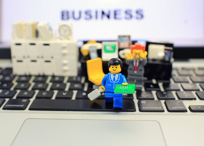 LEGO® Minifigure Holding Money Walking Across Keyboard
